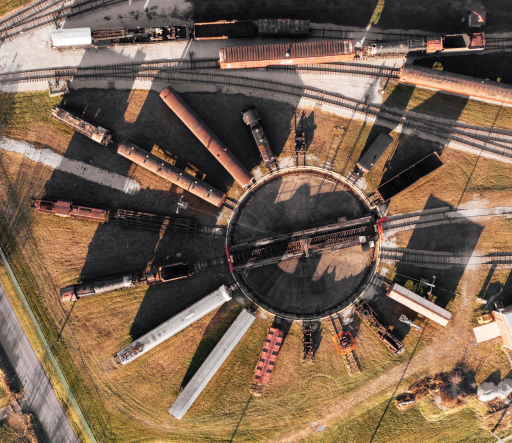 Aerial top view of a railroad turntable with trains on the tracks on a sunny day